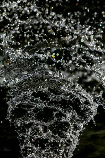 İçinde karanlık bir uçuş, ufuk bokeh su damlaları ile su sıçrama.