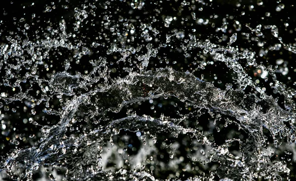 İçinde karanlık bir uçuş, ufuk bokeh su damlaları ile su sıçrama.