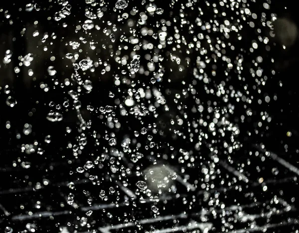 İçinde karanlık bir uçuş, ufuk bokeh su damlaları ile su sıçrama.