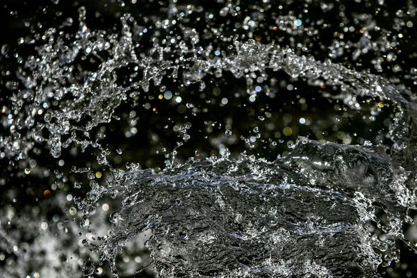 İçinde karanlık bir uçuş, ufuk bokeh su damlaları ile su sıçrama.