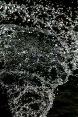 İçinde karanlık bir uçuş, ufuk bokeh su damlaları ile su sıçrama.