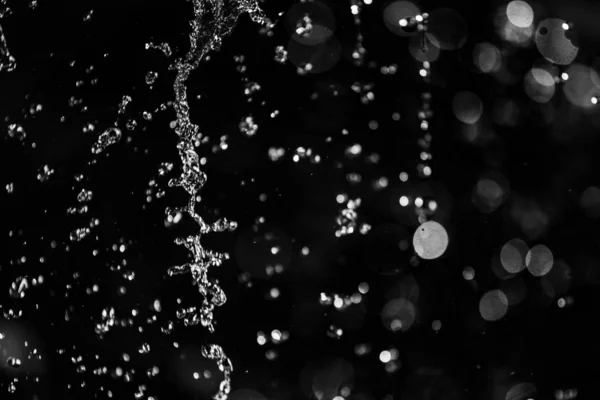 Salpicos Água Escuro Com Uma Gota Água Voando Bokeh Desfocado — Fotografia de Stock