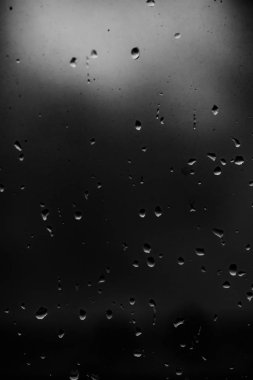 Karanlık cam arka plan üzerinde yağmur damlaları