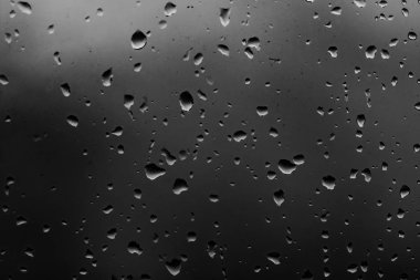 Karanlık cam arka plan üzerinde yağmur damlaları