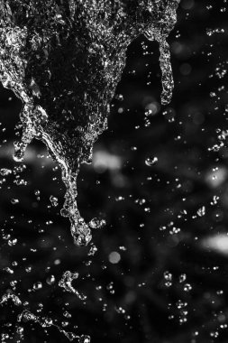 İçinde karanlık bir uçuş, ufuk bokeh su damlaları ile su sıçrama.