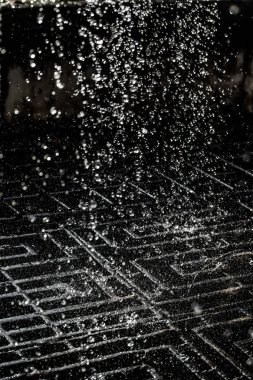 İçinde karanlık bir uçuş, ufuk bokeh su damlaları ile su sıçrama.