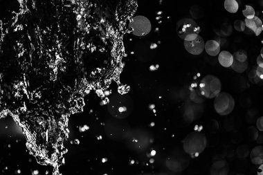 İçinde karanlık bir uçuş, ufuk bokeh su damlaları ile su sıçrama.