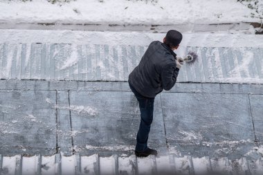 bir süpürge ile kar adam süpürür