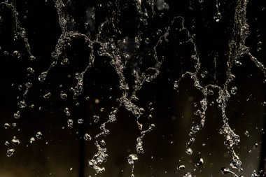 İçinde karanlık bir uçuş, ufuk bokeh su damlaları ile su sıçrama.