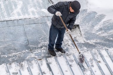 bir süpürge ile kar adam süpürür