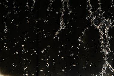 İçinde karanlık bir uçuş, ufuk bokeh su damlaları ile su sıçrama.