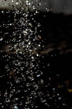 İçinde karanlık bir uçuş, ufuk bokeh su damlaları ile su sıçrama.