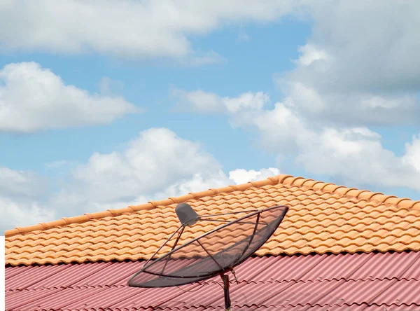 antenna on the roof of the house, the sky clouds