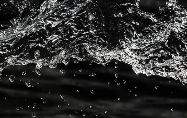 water drops in the air on a dark bokeh background