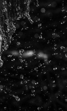 İçinde karanlık bir uçuş, ufuk bokeh su damlaları ile su sıçrama.