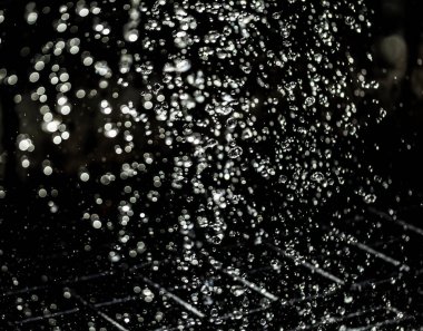 İçinde karanlık bir uçuş, ufuk bokeh su damlaları ile su sıçrama.