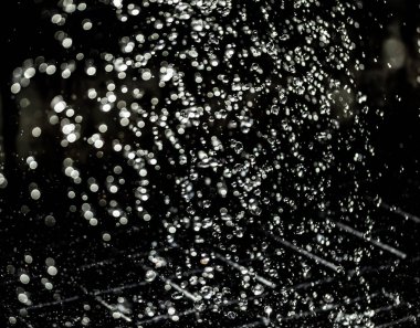 İçinde karanlık bir uçuş, ufuk bokeh su damlaları ile su sıçrama.