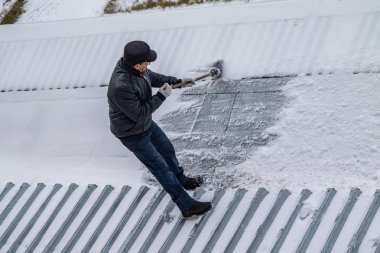 bir süpürge ile kar adam süpürür