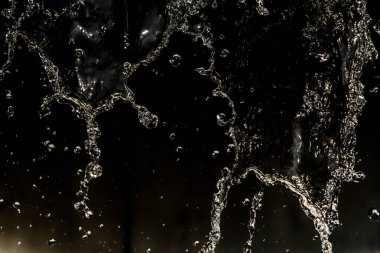 İçinde karanlık bir uçuş, ufuk bokeh su damlaları ile su sıçrama.