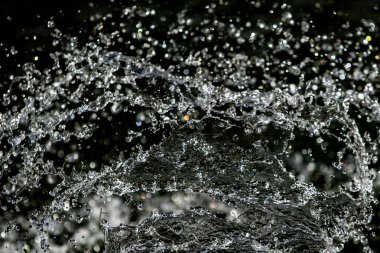 İçinde karanlık bir uçuş, ufuk bokeh su damlaları ile su sıçrama.