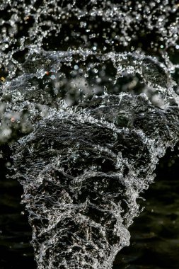 İçinde karanlık bir uçuş, ufuk bokeh su damlaları ile su sıçrama.