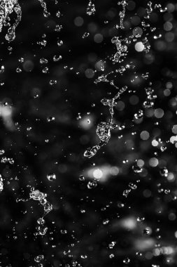 İçinde karanlık bir uçuş, ufuk bokeh su damlaları ile su sıçrama.