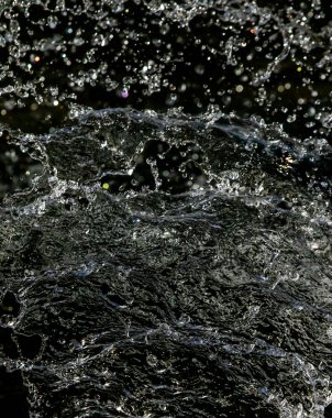 İçinde karanlık bir uçuş, ufuk bokeh su damlaları ile su sıçrama.