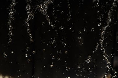 İçinde karanlık bir uçuş, ufuk bokeh su damlaları ile su sıçrama.