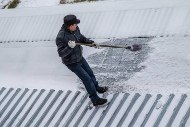 bir süpürge ile kar adam süpürür