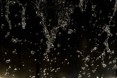 İçinde karanlık bir uçuş, ufuk bokeh su damlaları ile su sıçrama.