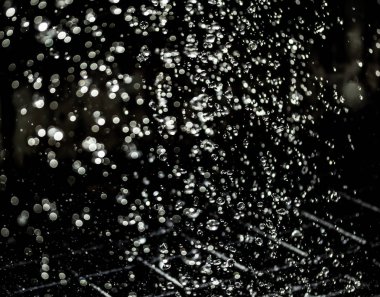 İçinde karanlık bir uçuş, ufuk bokeh su damlaları ile su sıçrama.