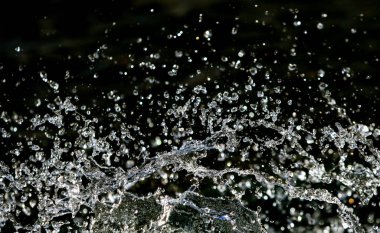 İçinde karanlık bir uçuş, ufuk bokeh su damlaları ile su sıçrama.