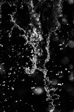 İçinde karanlık bir uçuş, ufuk bokeh su damlaları ile su sıçrama.