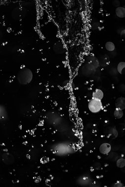 İçinde karanlık bir uçuş, ufuk bokeh su damlaları ile su sıçrama.