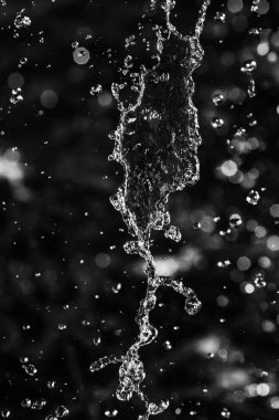 İçinde karanlık bir uçuş, ufuk bokeh su damlaları ile su sıçrama.