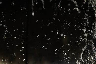 İçinde karanlık bir uçuş, ufuk bokeh su damlaları ile su sıçrama.