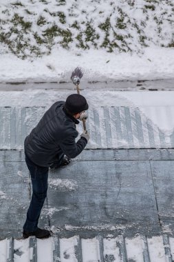 bir süpürge ile kar adam süpürür
