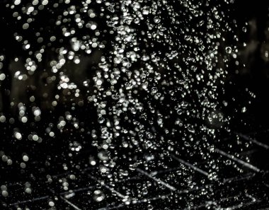 İçinde karanlık bir uçuş, ufuk bokeh su damlaları ile su sıçrama.