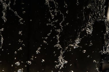 İçinde karanlık bir uçuş, ufuk bokeh su damlaları ile su sıçrama.