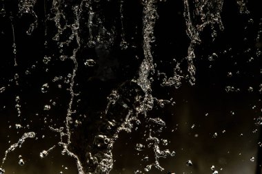 İçinde karanlık bir uçuş, ufuk bokeh su damlaları ile su sıçrama.