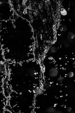 İçinde karanlık bir uçuş, ufuk bokeh su damlaları ile su sıçrama.