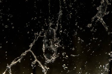 İçinde karanlık bir uçuş, ufuk bokeh su damlaları ile su sıçrama.