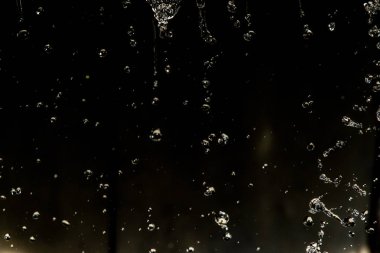 İçinde karanlık bir uçuş, ufuk bokeh su damlaları ile su sıçrama.