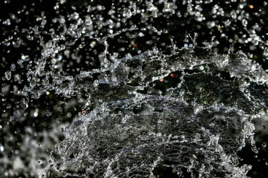 İçinde karanlık bir uçuş, ufuk bokeh su damlaları ile su sıçrama.