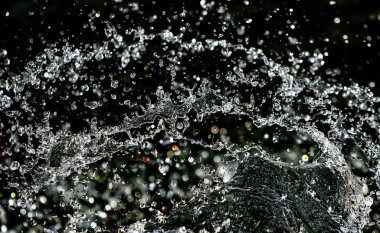 İçinde karanlık bir uçuş, ufuk bokeh su damlaları ile su sıçrama.