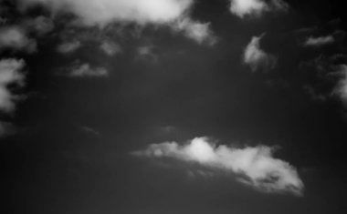 Beyaz bulutların üzerinde karanlık bir gökyüzü, tek renkli