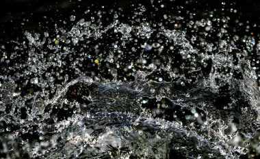 İçinde karanlık bir uçuş, ufuk bokeh su damlaları ile su sıçrama.