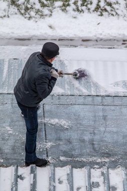 bir süpürge ile kar adam süpürür