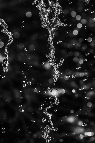 Wasserspritzer Dunkeln Mit Einem Tropfen Fliegendem Wasser Defokussiertes Bokeh — Stockfoto