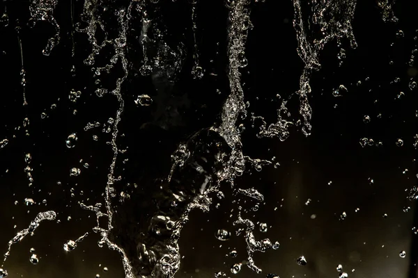 İçinde karanlık bir uçuş, ufuk bokeh su damlaları ile su sıçrama.